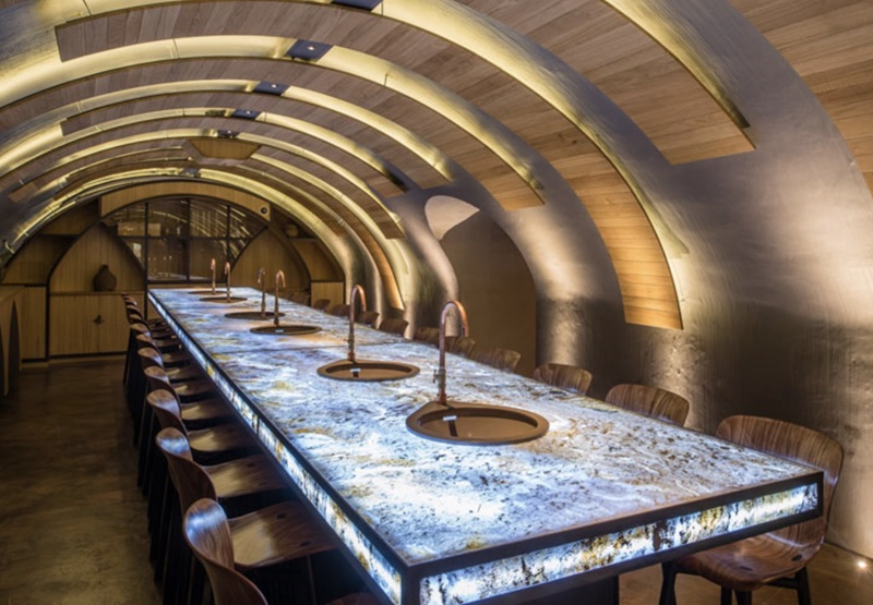 LED light sheets illuminating a translucent stone dining table and curved interior
